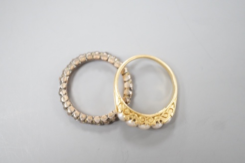 A 19th century yellow metal and rose diamond set full eternity ring, size L/M and an early 20th century yellow metal and graduated split pearl ring, size K/L, gross weight 5.8 grams.